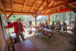 A visiting forester at the Demonstration Forest shows scouts the burn scar from the 2018 Ute Park Fire. The Demo Forest, located near the Cimarroncito Reservoir, showcases a variety of Philmont's forestry practices including those that help mitigate the risk of future wildfires.